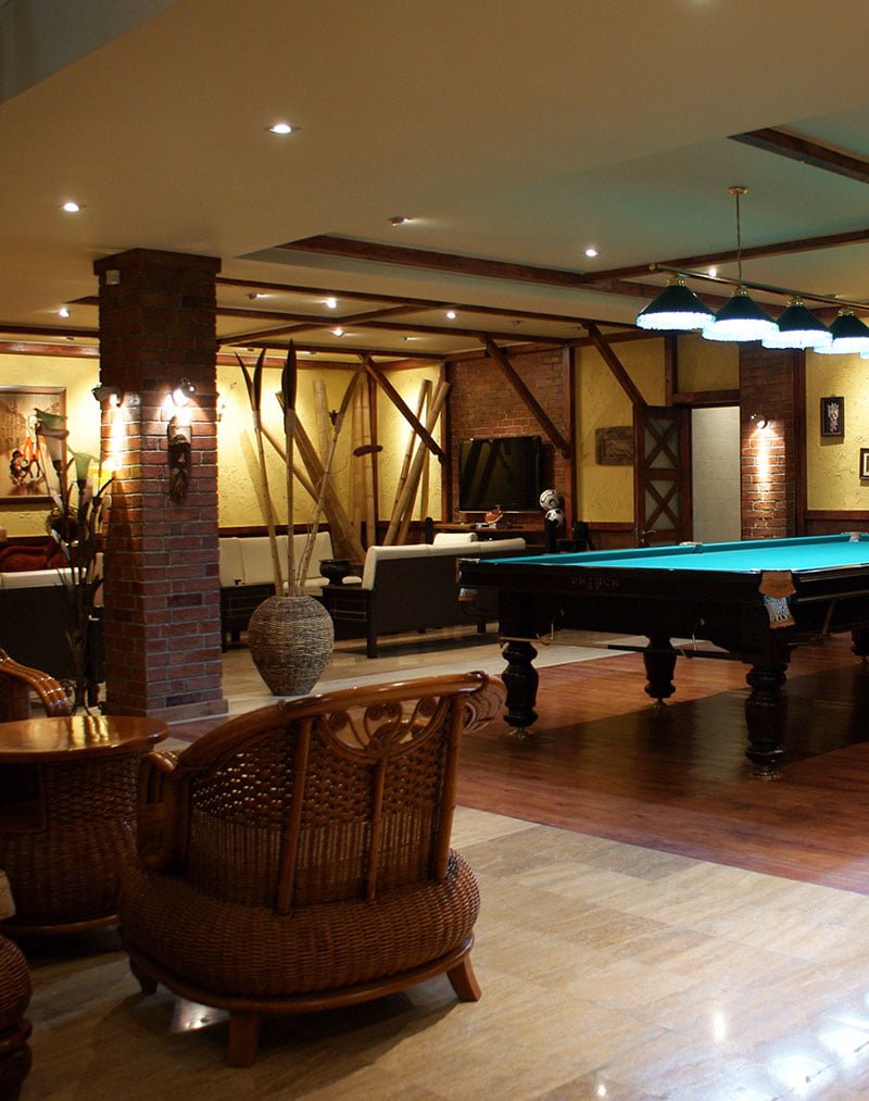photo of the basement of a private house with a games room, TV and fireplace areas