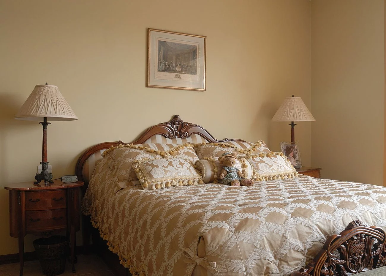 фото кровати с декором резьбы и атласа с антикварными прикроватными тумбочками