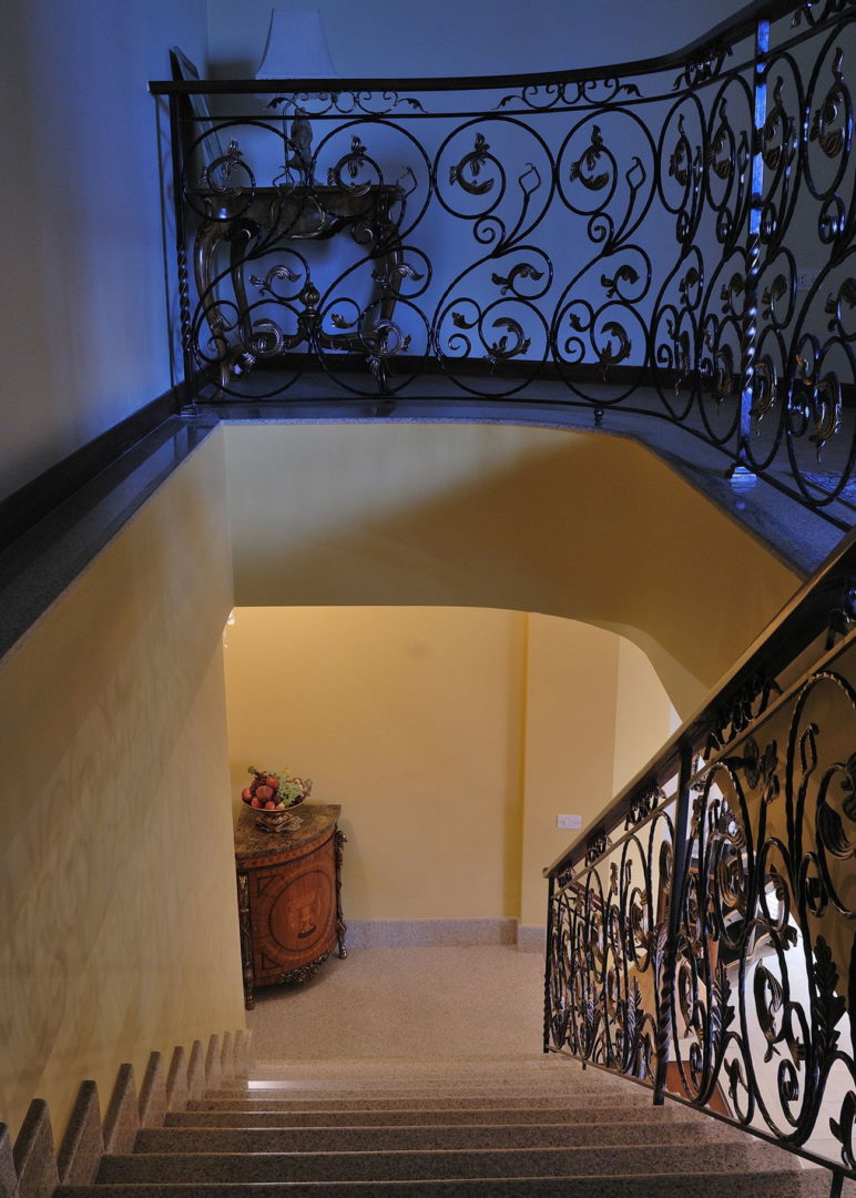 photo of stairs to the 2nd floor of a duplex with handmade wrought iron railings with gilding