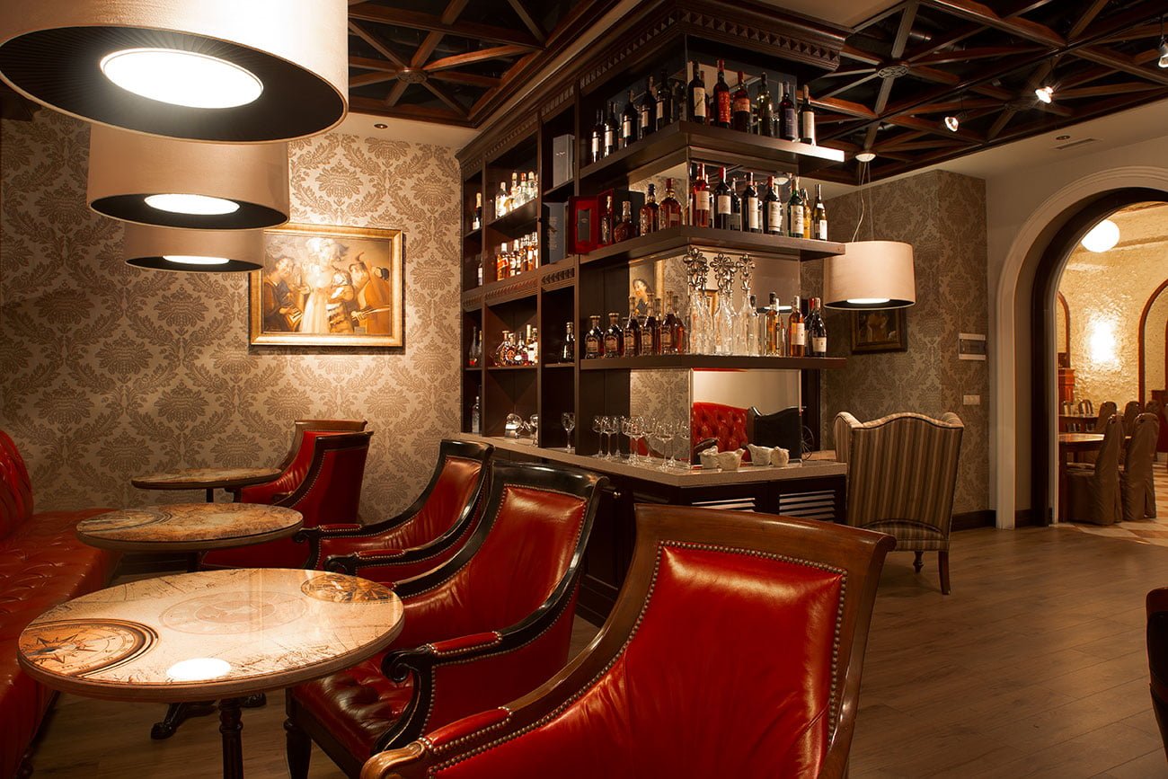 photo of cozy tables in JAZZVE CIGARS CLUB with armchairs upholstered in red leather