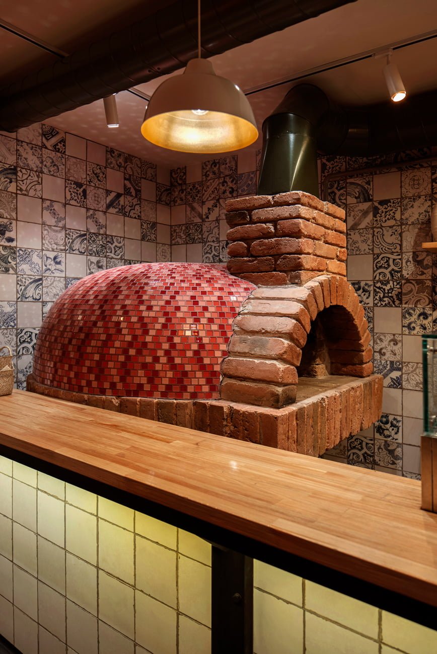 фотография каменной печи в ресторане ПОМОДОРО, в которой повара готовят пиццу
