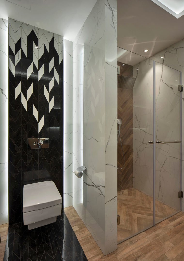 photo of a shower and toilet in a children's room with a black and white abstract mosaic
