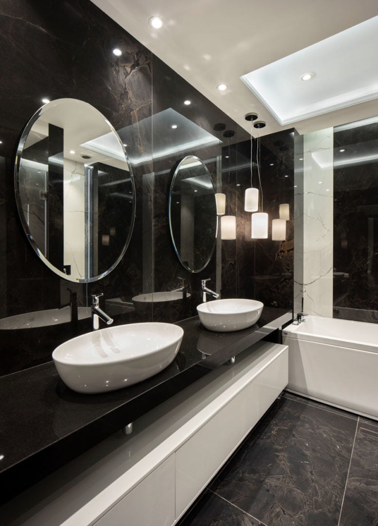 photo of the master bathroom finished with dark marble in contrast to white furniture