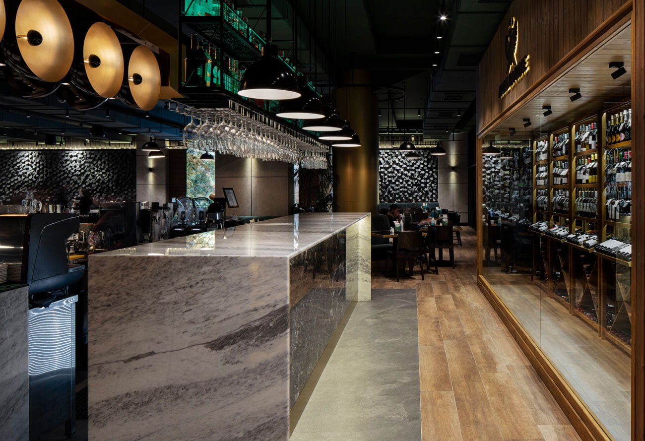 photo of a bar counter made of natural stone with a large wine cabinet in Downtown