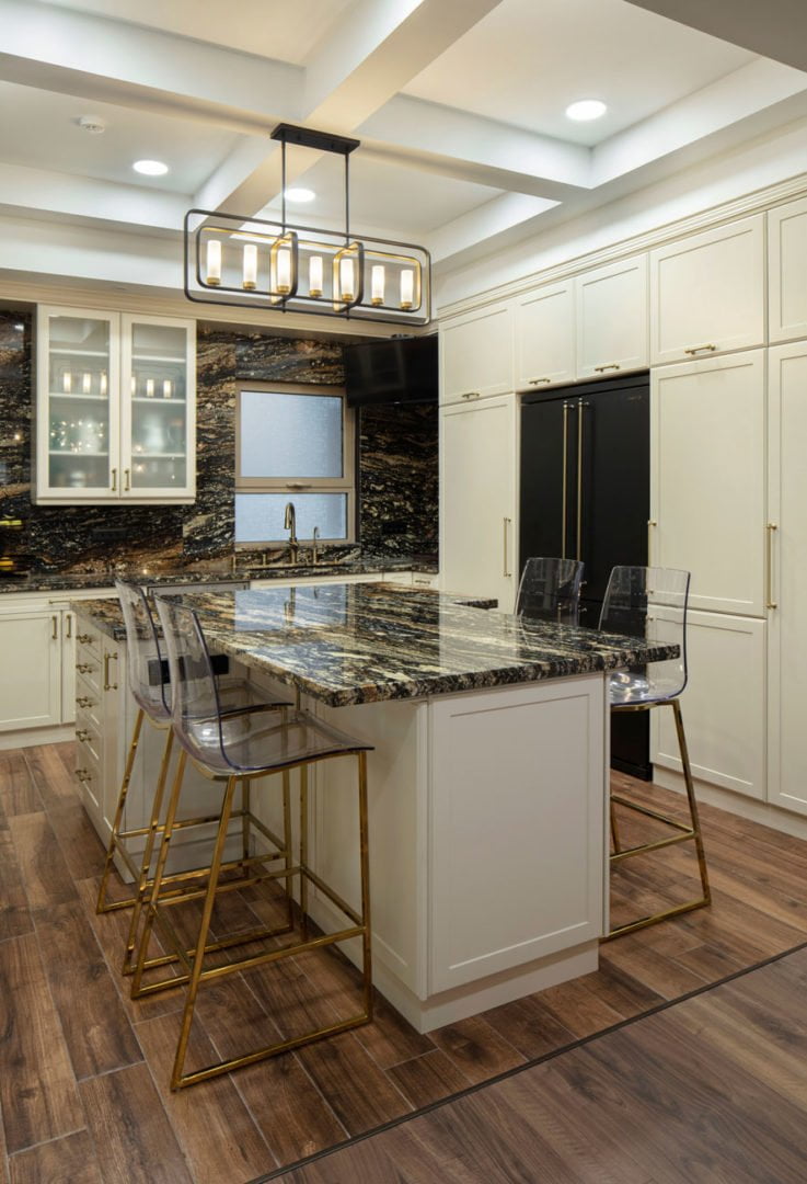 фото кухонной зоны с белой мебелью и островом стилизована под классический стиль